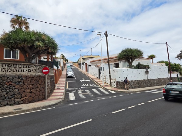Calle en pendiente con señal de stop y viviendas típicas en Bajamar.