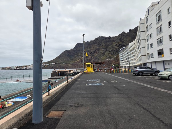 Vía peatonal y rodona junto al borde del mar con edificios residenciales en Bajamar.