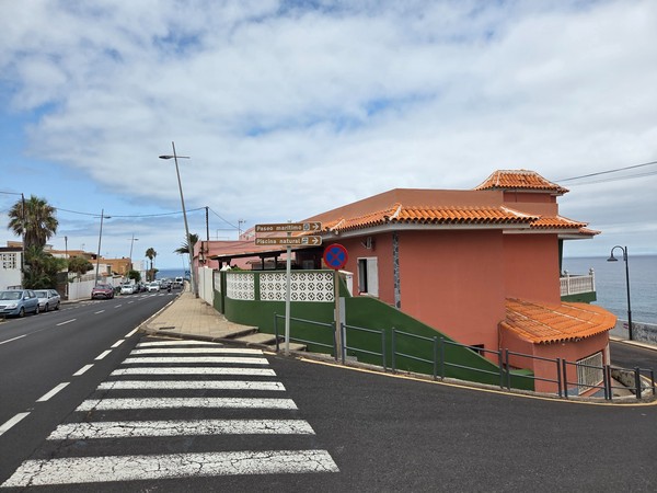 Señales marrones indicativas hacia el paseo marítimo y la piscina natural de Bajamar.