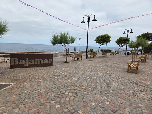 Rótulo metálico con la palabra Bajamar en la plaza junto al paseo marítimo.