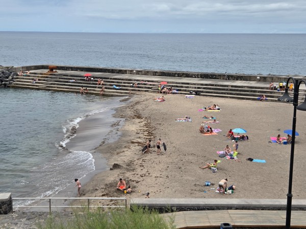 Familias y sombrillas en la playa urbana contigua a las piscinas de Bajamar.