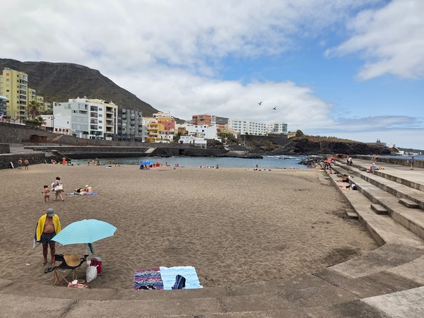 Panorámica de la playa de Bajamar con edificios residenciales y montañas al fondo.