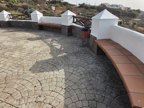 Mirador con bancos curvos y barandilla de madera sobre el barranco, en la ruta hacia Candelaria.