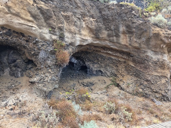Pequeñas cuevas costeras y estratos volcánicos junto al sendero en Acentejo.