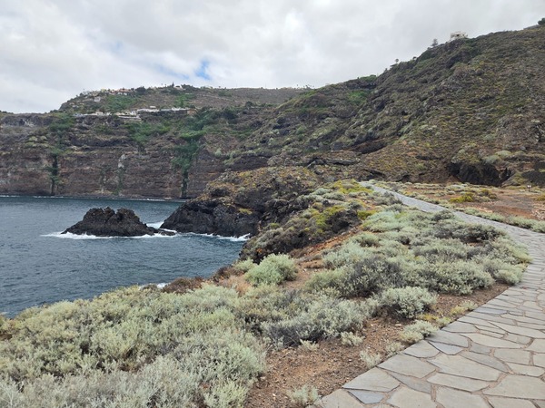Paseo adoquinado con muros de piedra volcánica y amplias vistas al mar en la Costa de Acentejo.