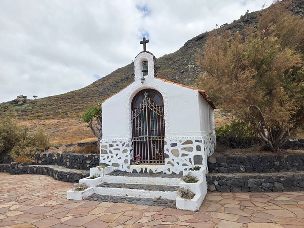 Pequeña ermita blanca de Rojas con fachada sencilla y campanil, enmarcada por tabaibas.