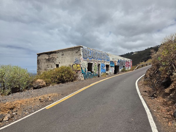 Edificación en ruinas con grafitis junto a la carretera secundaria del litoral.