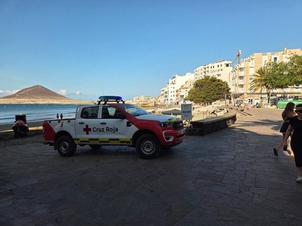 Vehículo de la Cruz Roja en la plaza junto a la playa de El Médano con Montaña Roja al fondo.