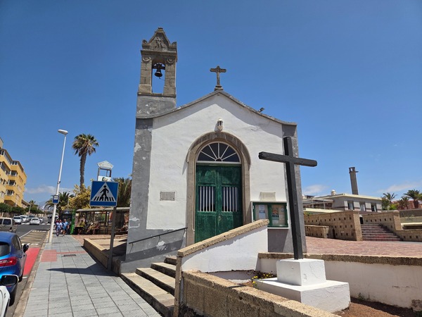 Ermita blanca con campanario y gran cruz en la avenida principal de El Médano.