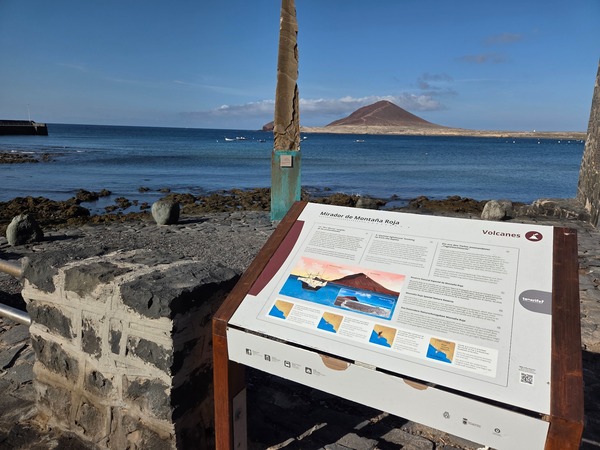 Panel interpretativo del Mirador de Montaña Roja con la bahía de El Médano de fondo.