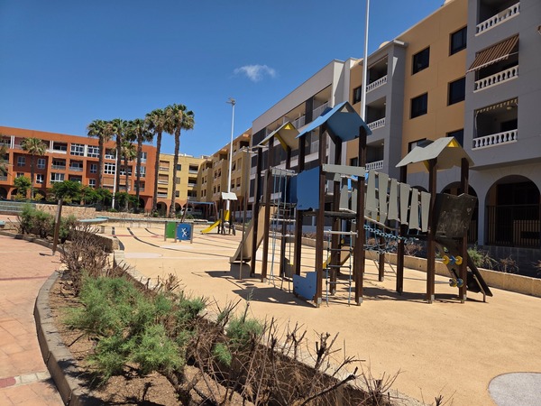 Zona infantil con juegos y toboganes en un área residencial de El Médano.