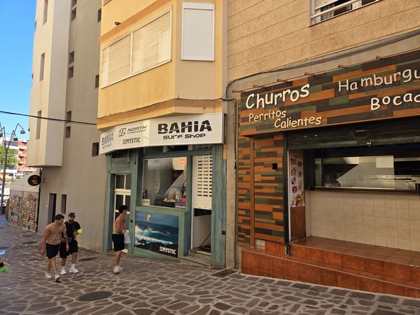 Bahía Surf Shop y churrería en una calle peatonal de El Médano.