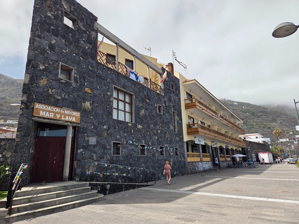 Edificio de piedra volcánica con balcones de madera en el frente marítimo de Garachico.