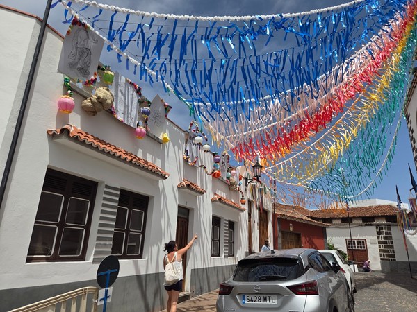 Calle decorada con cintas de colores colgantes y farolillos en Garachico.