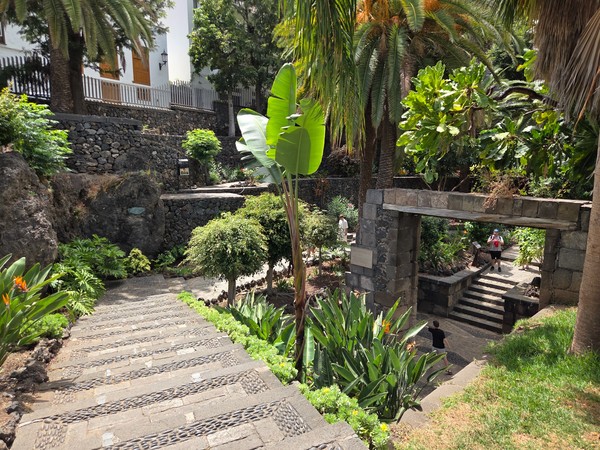 Parque ajardinado de Garachico con terrazas de piedra, escaleras y plantas tropicales.