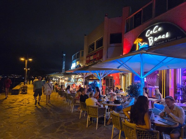 Paseo marítimo cercano con bares iluminados y terrazas en plena noche en el sur de Tenerife.