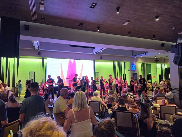 Público levantando los brazos durante una actuación en el escenario del Hard Rock Café Tenerife.