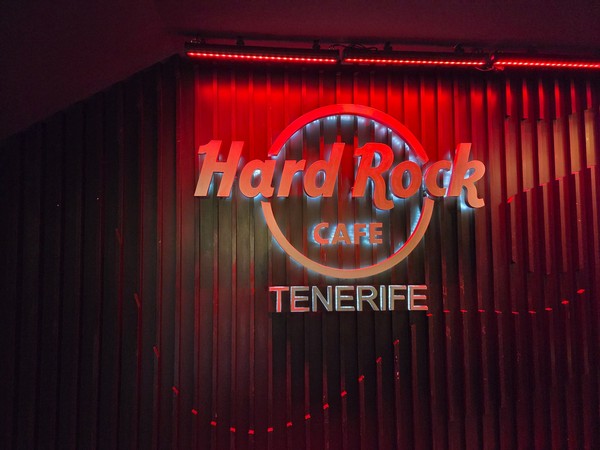 Cantante y banda actuando en el escenario de la terraza del Hard Rock Café Tenerife al atardecer.