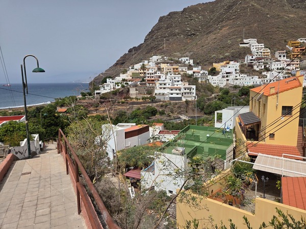 Primer plano de las casas blancas y coloridas escalonadas en la ladera.