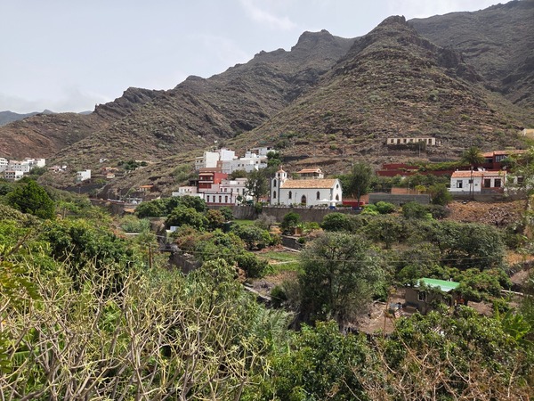 Panorama del valle con la iglesia y casas tradicionales al pie de las montañas.