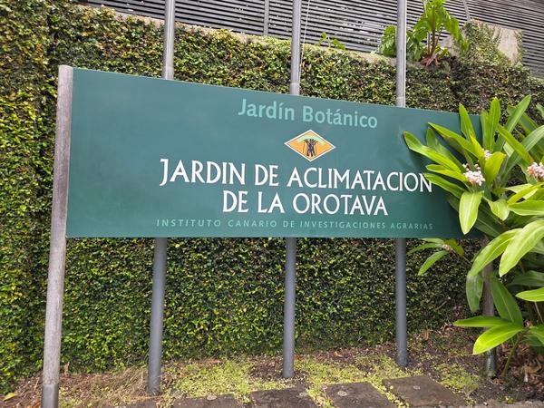 Cartel de entrada al Jardín de Aclimatación de La Orotava rodeado de vegetación tropical