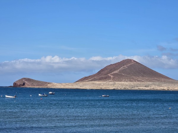 Vista panorámica de Montaña Roja desde El Médano con el cono volcánico recortado sobre el mar.