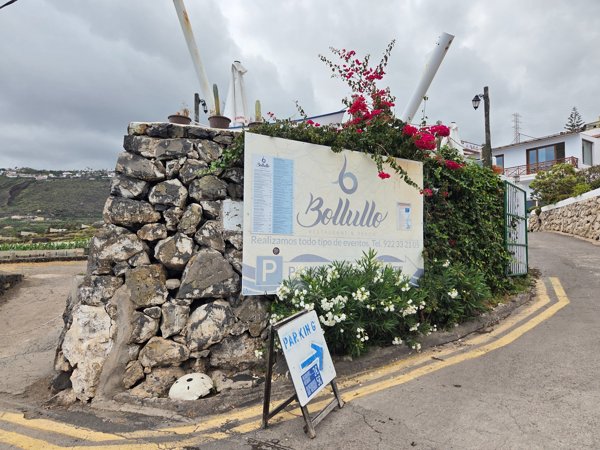 Cartel del restaurante Bollullo y señalización de aparcamiento en la entrada de la finca