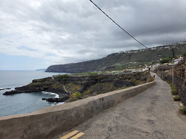 Camino asfaltado pegado al acantilado que conduce a Playa Bollullo con vistas a la costa norte de Tenerife