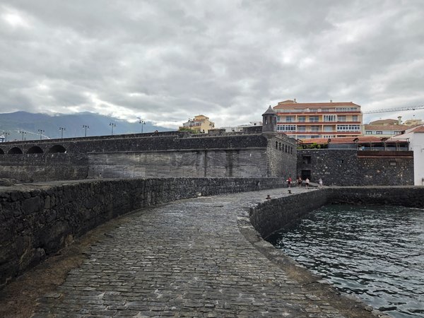 Camino empedrado sobre el espigón que conduce al mirador del viejo castillete defensivo.