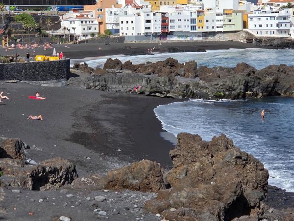 La zona del Charcón muestra piscinas naturales y bañistas disfrutando del mar.