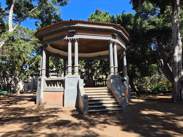 Templete o kiosco de música octogonal de la Plaza Príncipe de Asturias rodeado de grandes ficus.
