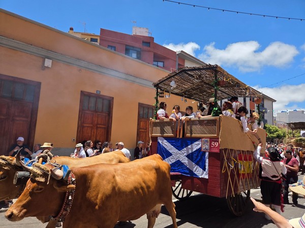 Carreta con banderas de Escocia y España repleta de romeros.