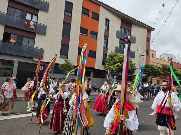 Grupo porta mástiles con cintas multicolor, símbolo festivo de la romería.