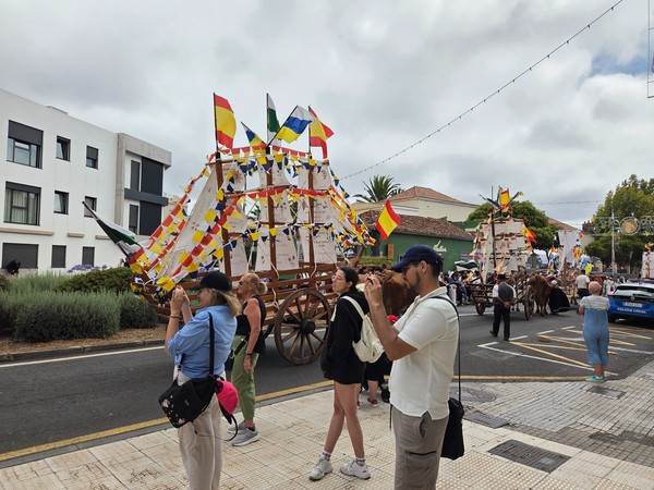 Carretas con forma de barco y gallardetes, fotografiadas por visitantes en la avenida.