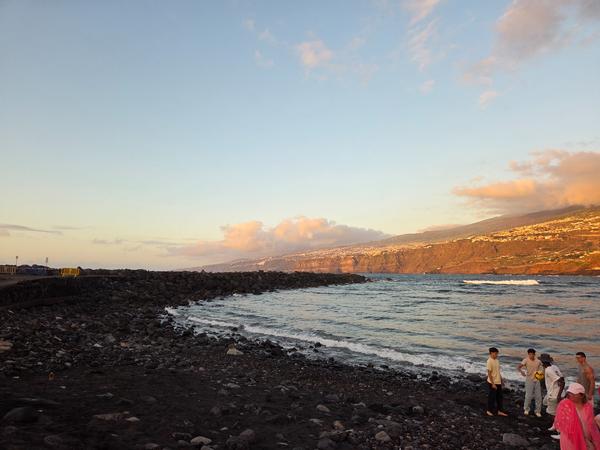 Vista del atardecer sobre la costa norte de Tenerife desde la playa de Puerto de la Cruz durante la víspera de San Juan.