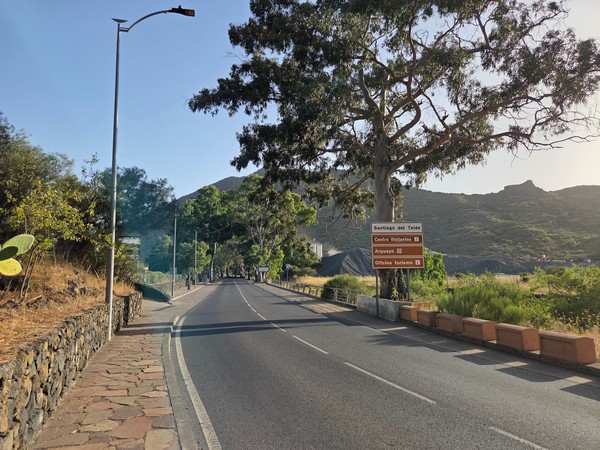 Señales turísticas que indican Santiago del Teide, Centro de Visitantes, Arguayo y la oficina de turismo junto a una carretera.