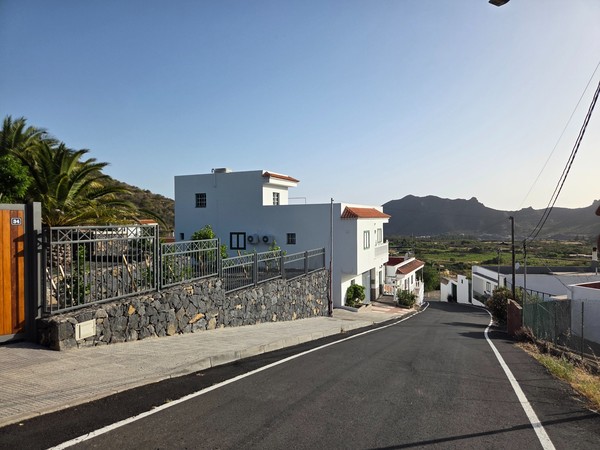 Vista panorámica desde una calle en el barrio de Valle Arriba con casas blancas y el valle de Santiago del Teide al fondo.