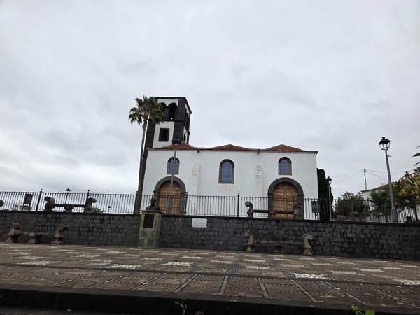 Iglesia del casco de Tacoronte Iglesia de Tacoronte con fachada blanca, torre de piedra oscura y plaza adoquinada en primer término.
