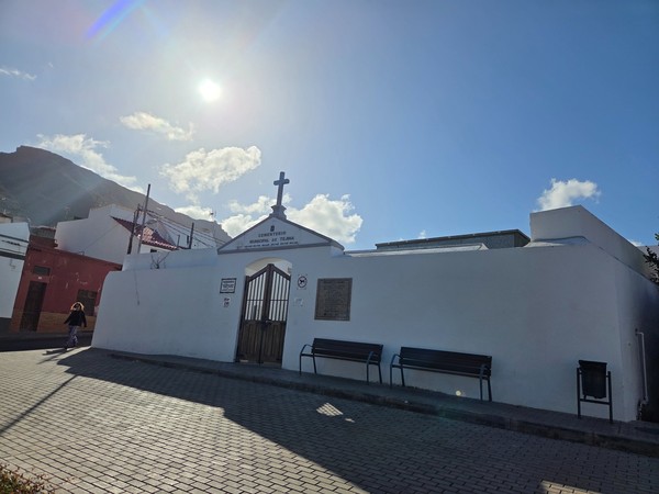 Entrada encalada del cementerio municipal de Tejina con cruz y bancos exteriores.